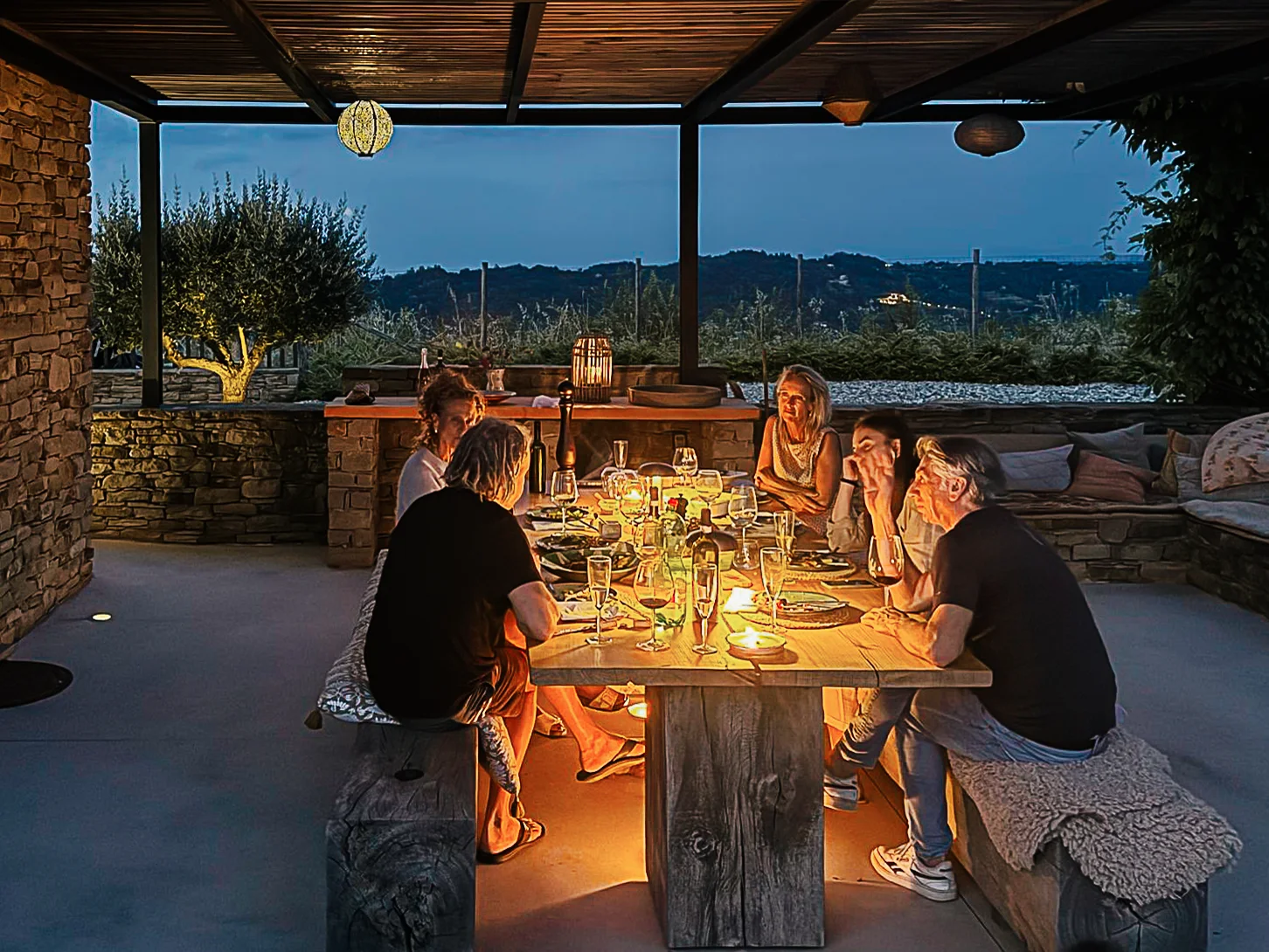 The terrace at dusk, dinner under the pergola